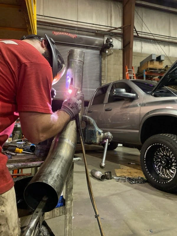 Fabrication work beside a vehicle in a workshop