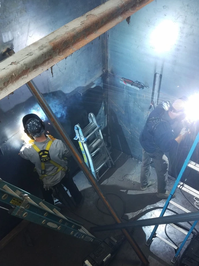 Welder working inside a metal tank